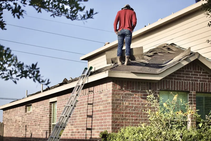 Professional roofer working on a residential roof in Timberland